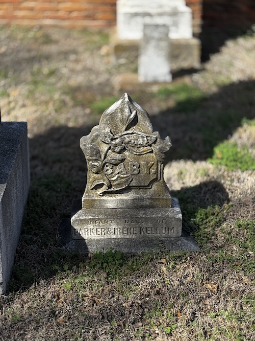 Image of a small upright headstone saying "baby" and "infant child of Parker & Irene Kellum.