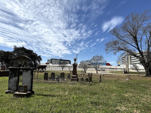 Image of cemetery and headstones with Interstate 35 running through the background to show how close it is.