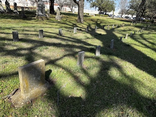 Image of two rows of upright headstones for Confederate Veterans.