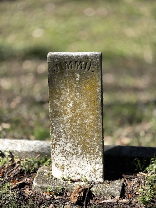 Image of plain upright headstone with just name "Jimmie" engraved on it.