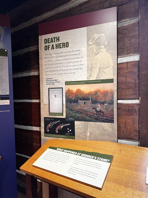Image of display with information about Lewis, titled "Death of a Hero". Below that is a small wooden stand with a display asking "What happened at Grinder's Stand?"